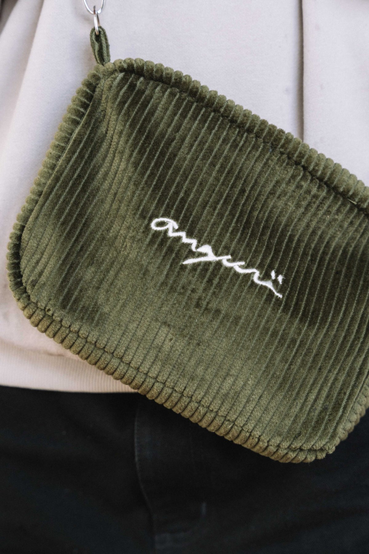 Khaki corduroy crossbody bag, front view with white angurä embroidery