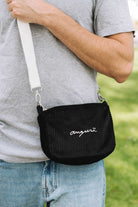 Black corduroy crossbody bag, worn across the body
