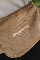 Camel corduroy crossbody bag, close-up of white angurä embroidery
